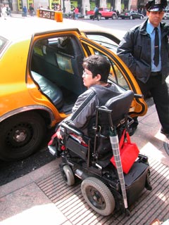 Picture of woman in a wheelchair and taxi
