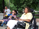 photo of a couple of disabled people in wheelchairs listening to speeches